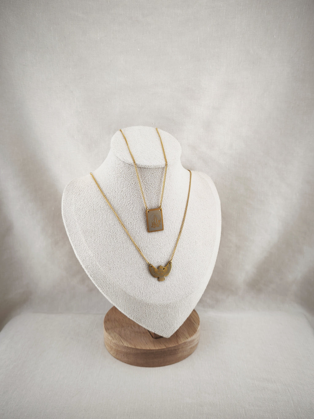 Colar Escapulário Anunciação dourado, com o Espírito Santo e medalha de Nossa Senhora de Fátima, apresentado em expositor.