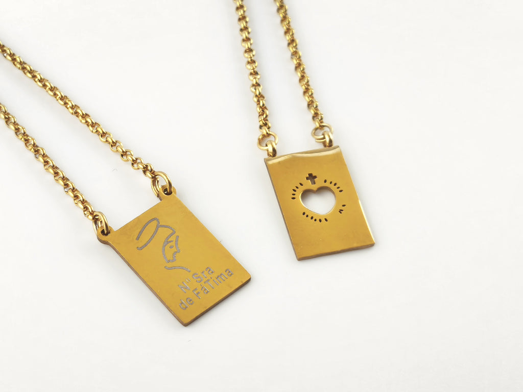 Colar Escapulário Refúgio dourado, pormenor das medalhas de Nossa Senhora de Fátima e do Sagrado Coração de Jesus.