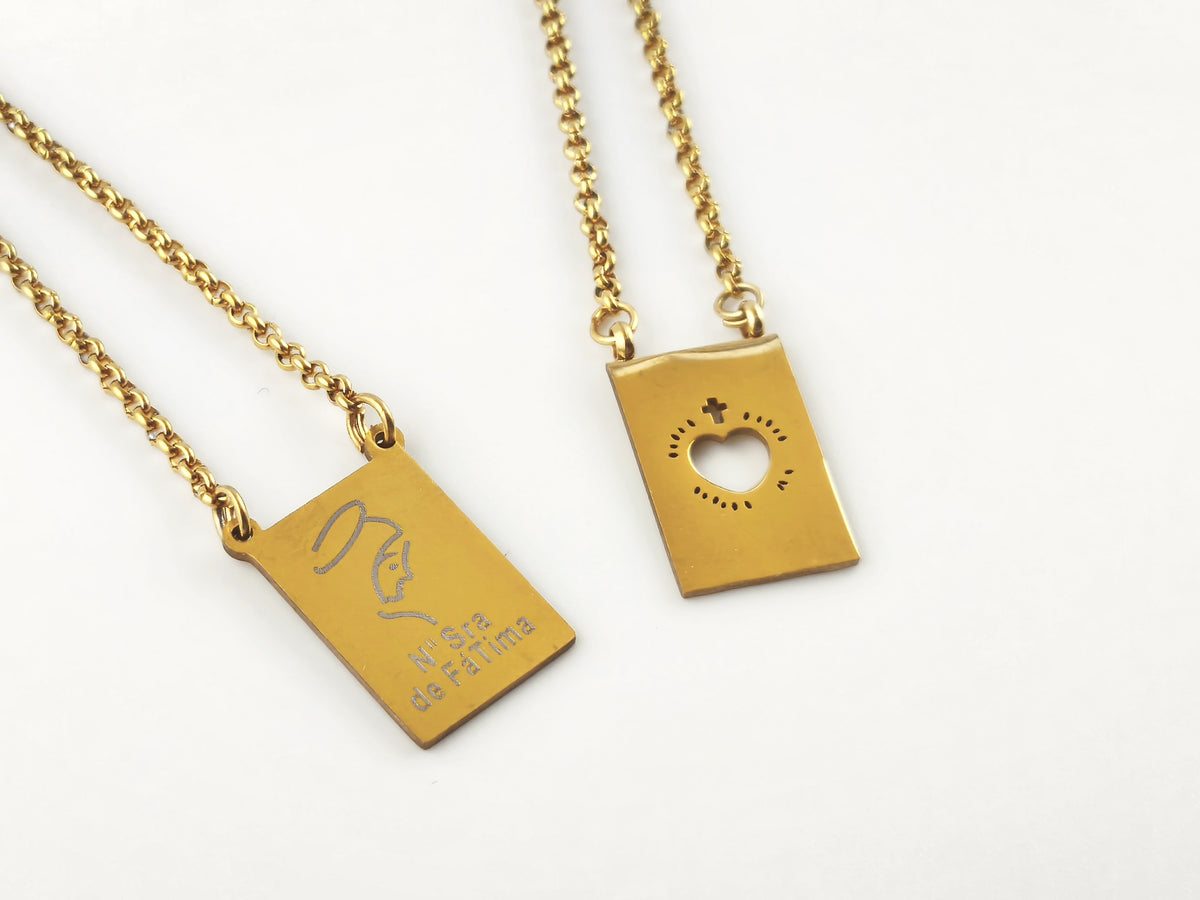 Colar Escapulário Refúgio dourado, pormenor das medalhas de Nossa Senhora de Fátima e do Sagrado Coração de Jesus.