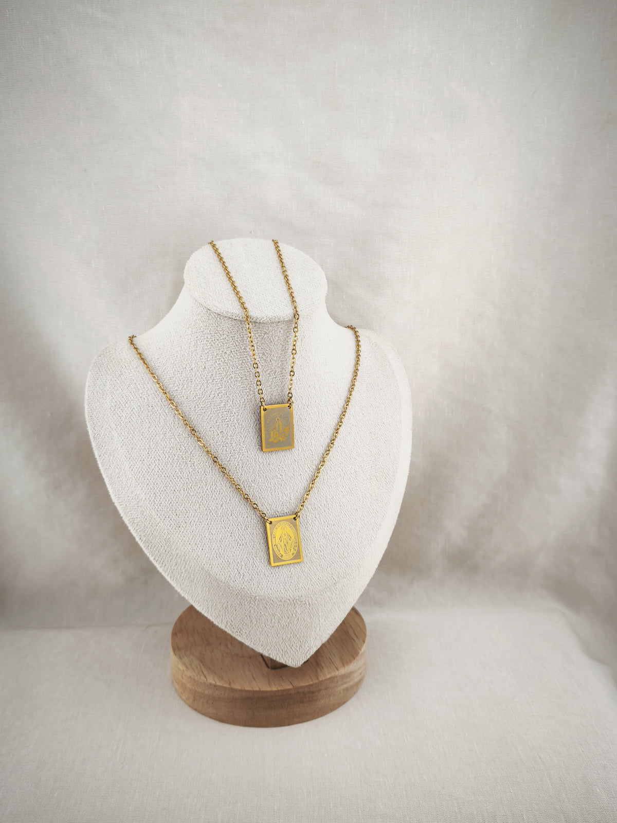 Colar Escapulário Candeia dourado, com medalhas de Nossa Senhora de Fátima e de Nossa Senhora das Graças, apresentado em expositor.