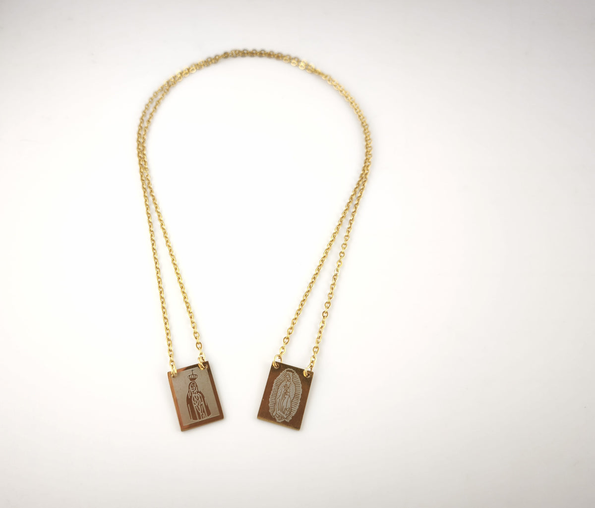 Colar Escapulário Além-Mar dourado, com medalhas de Nossa Senhora de Fátima e de Nossa Senhora de Guadalupe, vista de frente.