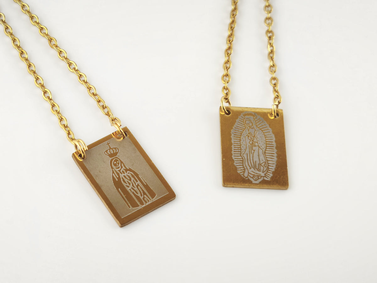 Colar Escapulário Além-Mar dourado, pormenor das medalhas de Nossa Senhora de Fátima e de Nossa Senhora de Guadalupe.