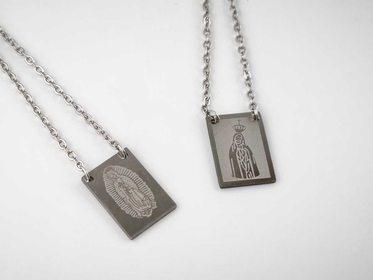 Colar Escapulário Além-Mar prateado, pormenor das medalhas de Nossa Senhora de Fátima e de Nossa Senhora de Guadalupe.