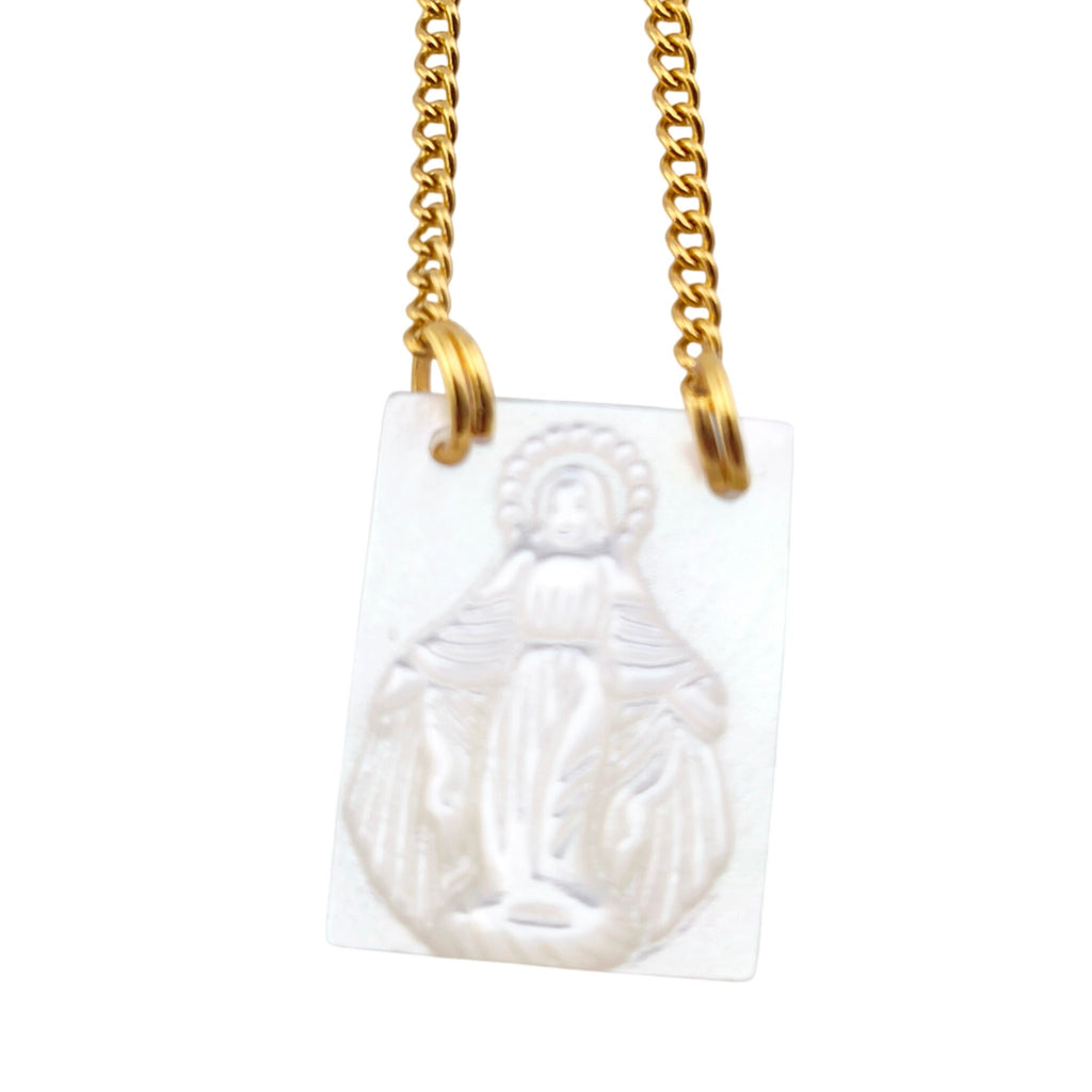 Colar Escapulário Sinal de Fé dourado, pormenor da medalha e da cruz, sobre fundo branco.