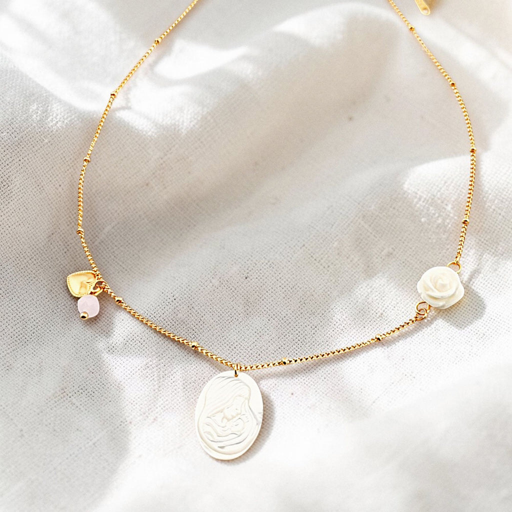 Colar gargantilha em aço inoxidável dourado com medalha em madre pérola N. S. do Carmo, cristal rosa, coração e rosa em resina. Coleção Religiosos | Joias de Fé