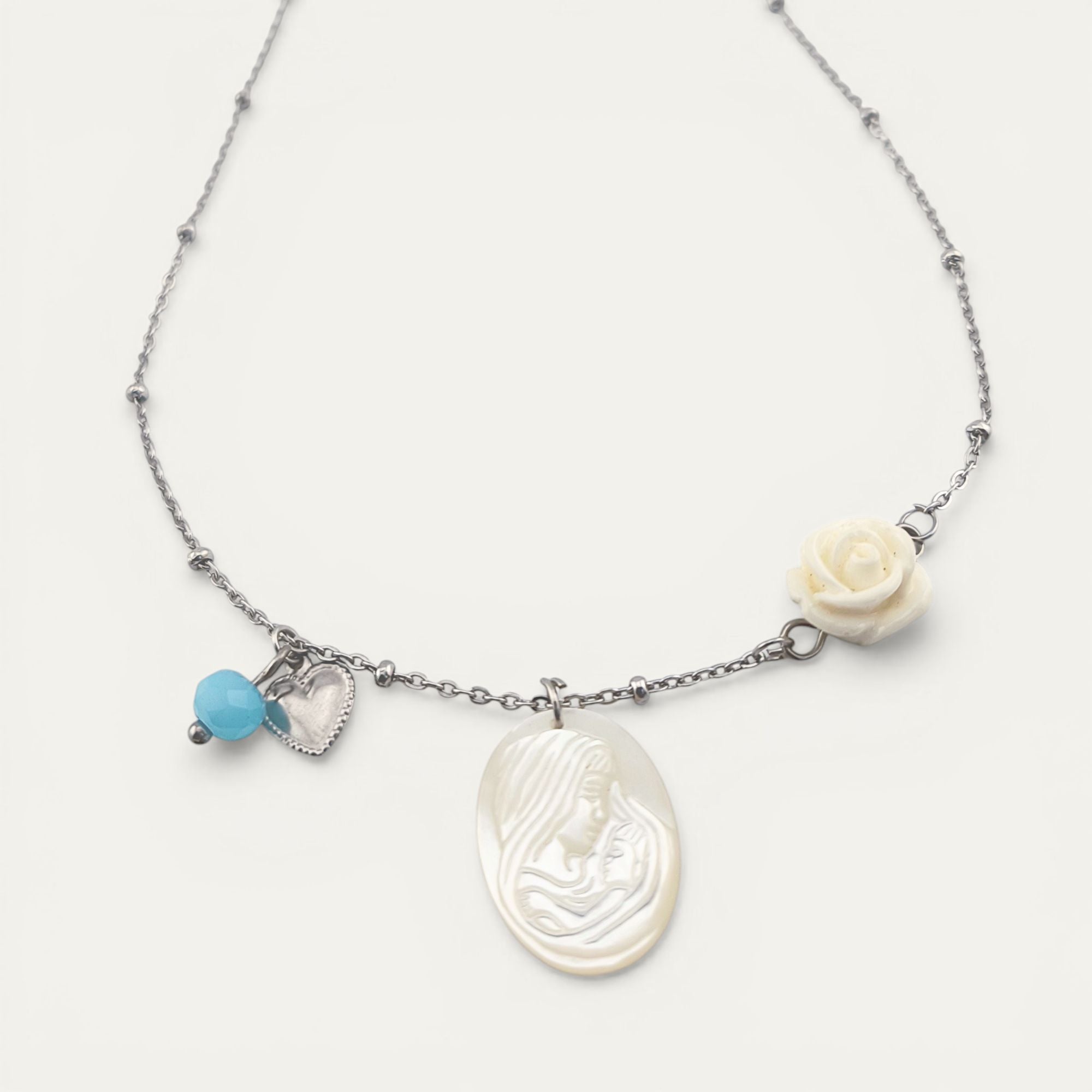 Colar gargantilha em aço inoxidável dourado com medalha em madre pérola N. S. do Carmo, cristal rosa, coração e rosa em resina. Coleção Religiosos | Joias de Fé