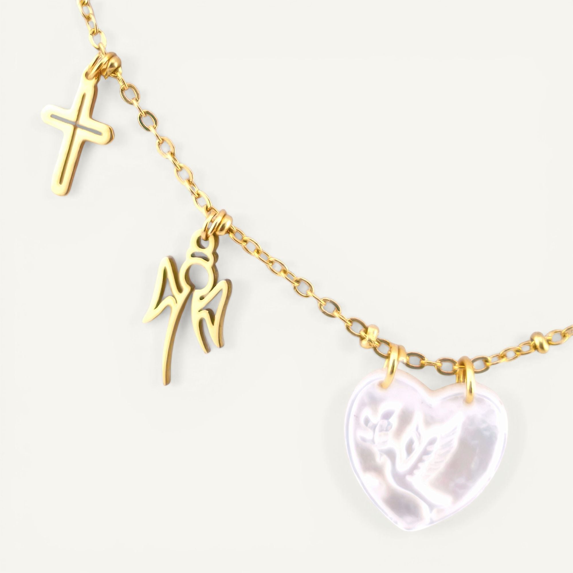 Colar gargantilha em aço inoxidável dourado com medalha coração em madre pérola e pendentes religiosos em aço. Coleção Religiosos | Joias de Fé