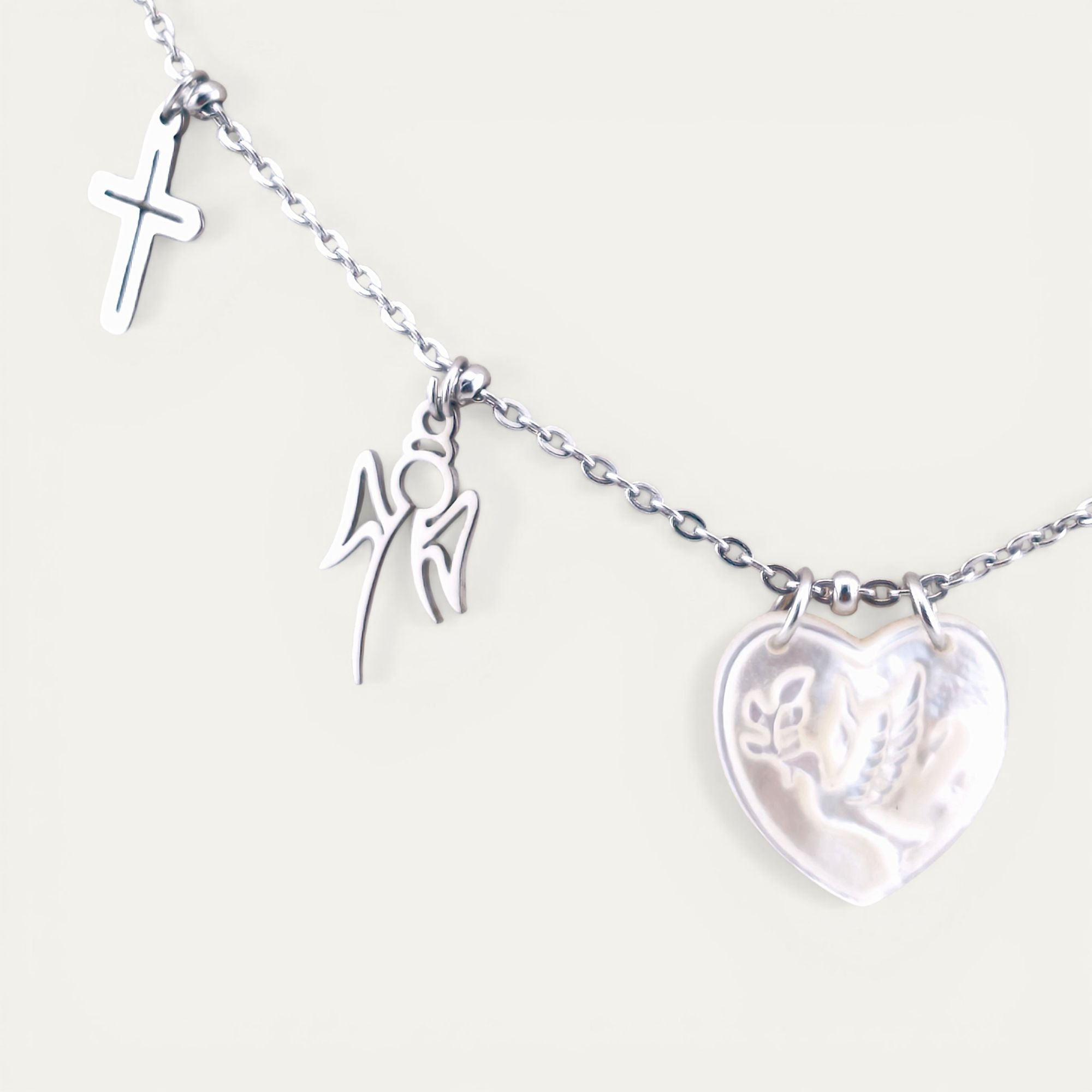 Colar gargantilha em aço inoxidável dourado com medalha coração em madre pérola e pendentes religiosos em aço. Coleção Religiosos | Joias de Fé