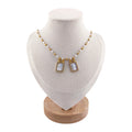 Colar Escapulário Luz Celestial dourado, com pérolas, apresentado em expositor.