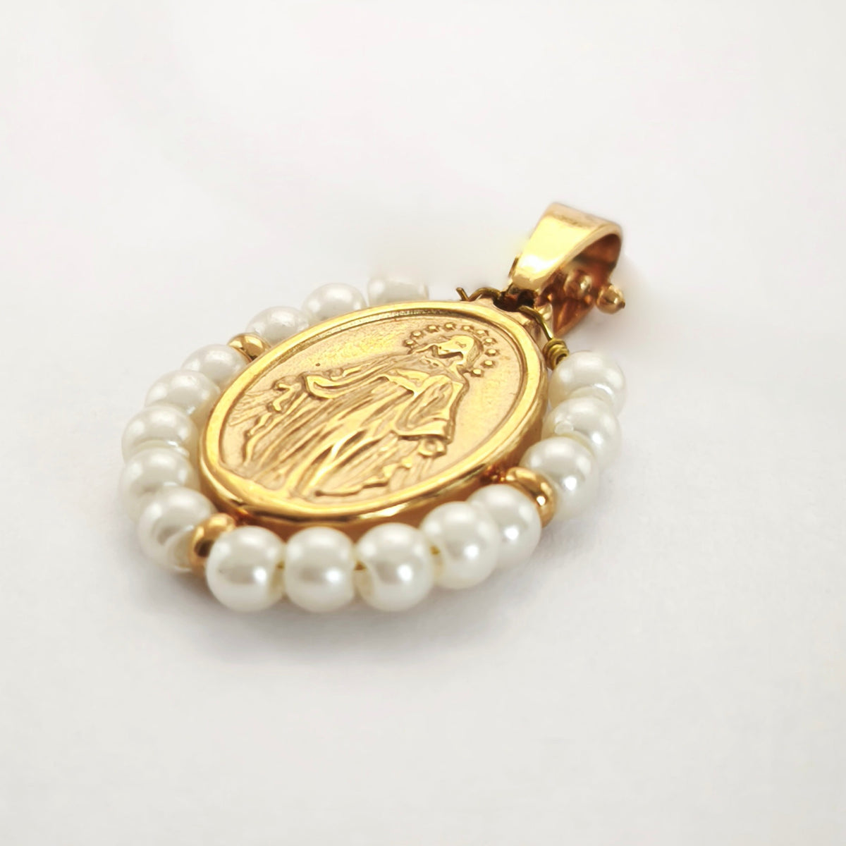 Pendente Orvalho dourado, com medalha de Nossa Senhora das Graças rodeada de pérolas artificiais, em perspetiva.
