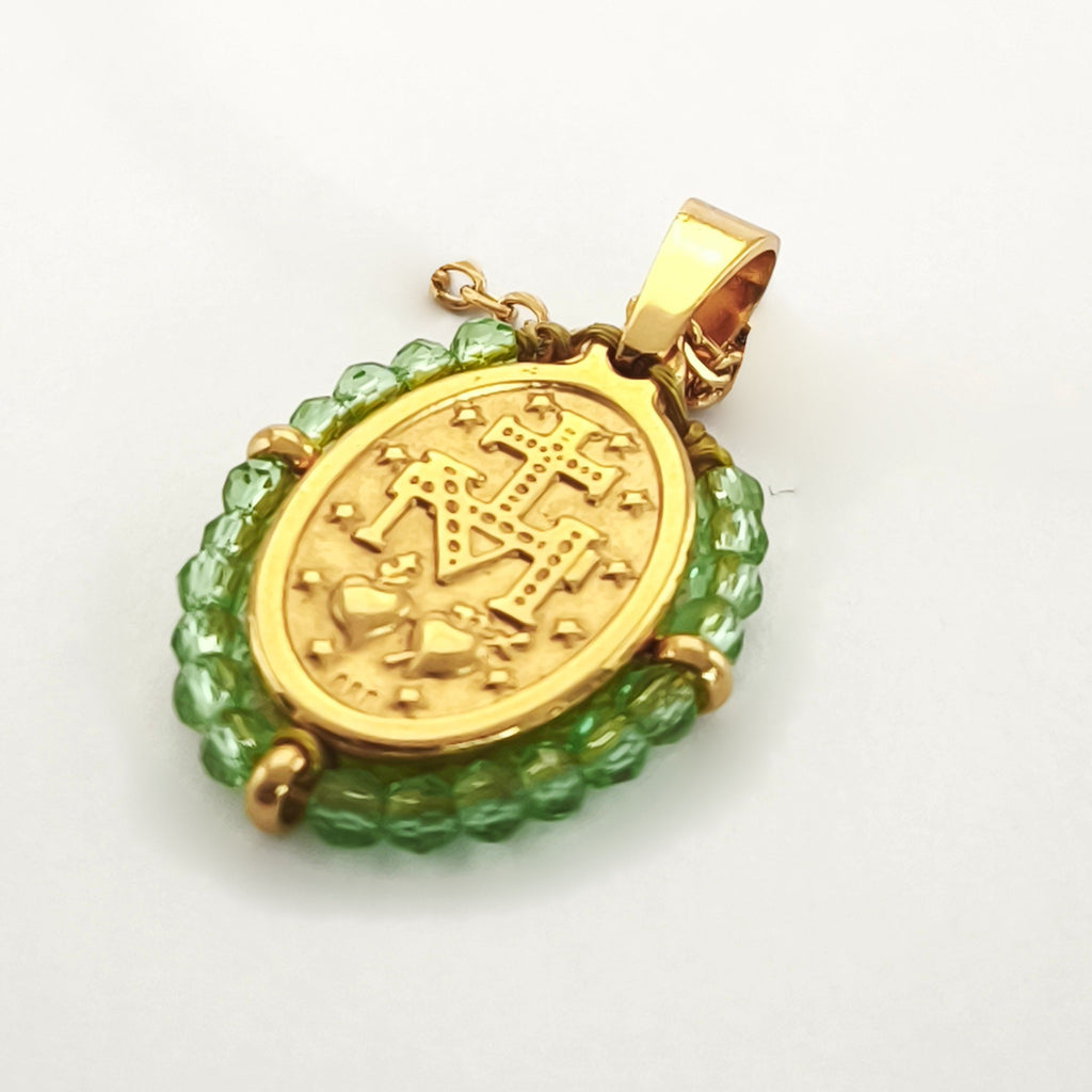 Pendente Orvalho dourado, verso da medalha rodeada de contas verde-lima, com a letra M, a cruz, os dois corações e as doze estrelas.