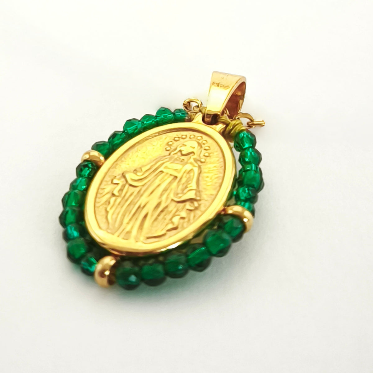 Pendente Orvalho dourado, com medalha de Nossa Senhora das Graças rodeada de contas verde menta, em perspetiva.
