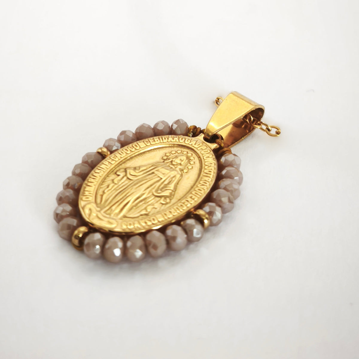 Pendente Auréola dourado, com medalha de Nossa Senhora das Graças rodeada de contas rosa irisado, em perspetiva.