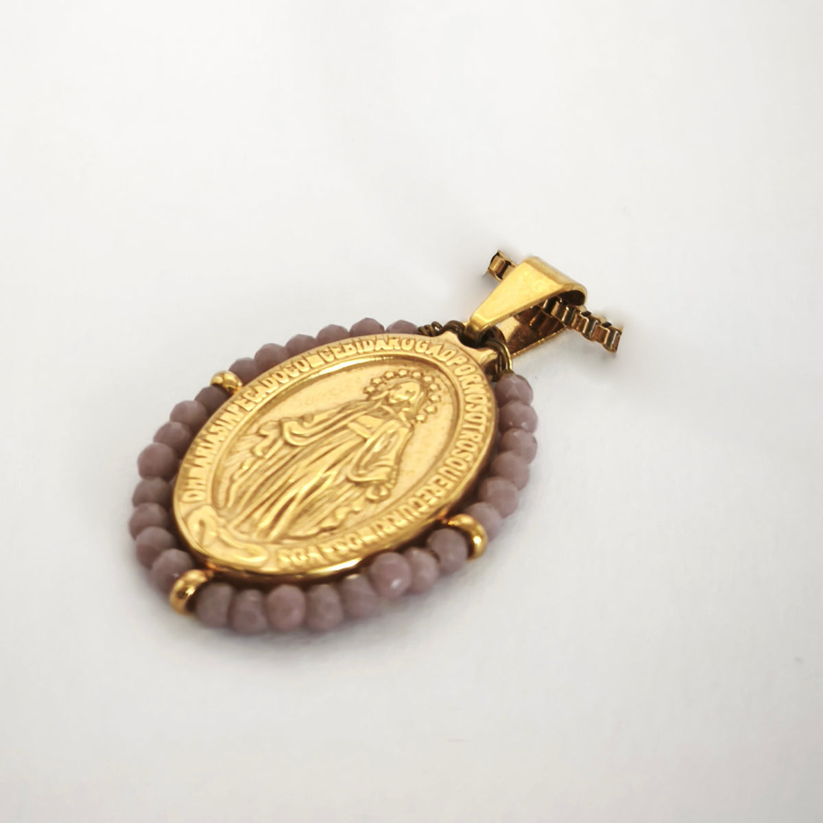 Pendente Auréola dourado, com medalha de Nossa Senhora das Graças rodeada de contas lilás, em perspetiva.