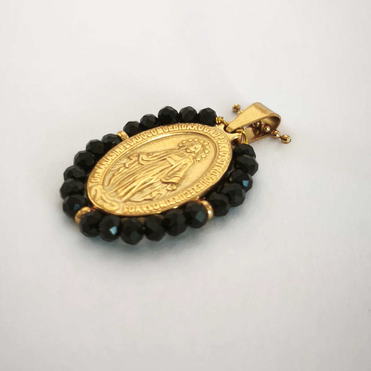 Pendente Auréola dourado, com medalha de Nossa Senhora das Graças rodeada de contas pretas, em perspetiva.