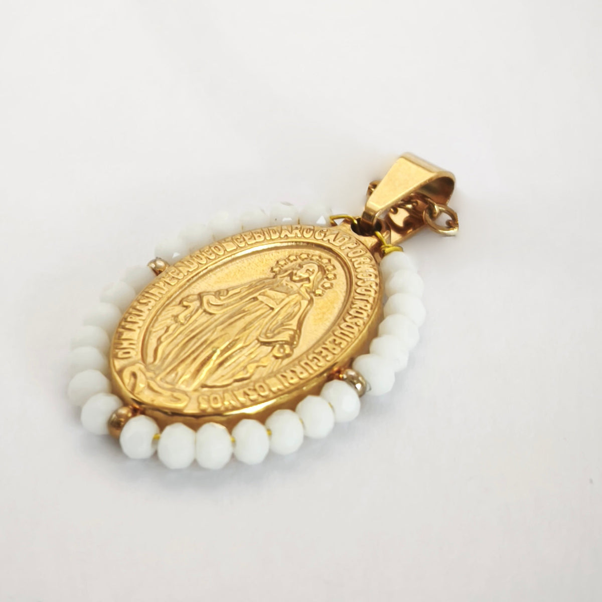 Pendente Auréola dourado, com medalha de Nossa Senhora das Graças rodeada de contas brancas, em perspetiva.