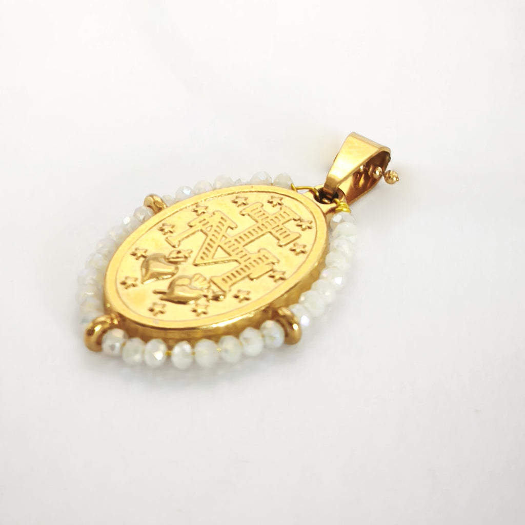 Pendente Auréola dourado, verso da medalha rodeada de contas branco irisado, com a letra M, a cruz, os dois corações e as doze estrelas.