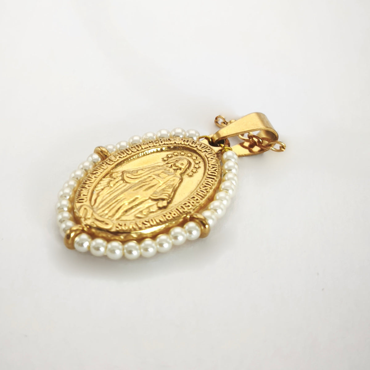 Pendente Auréola dourado, com medalha de Nossa Senhora das Graças rodeada de pérolas artificiais miúdas, em perspetiva.