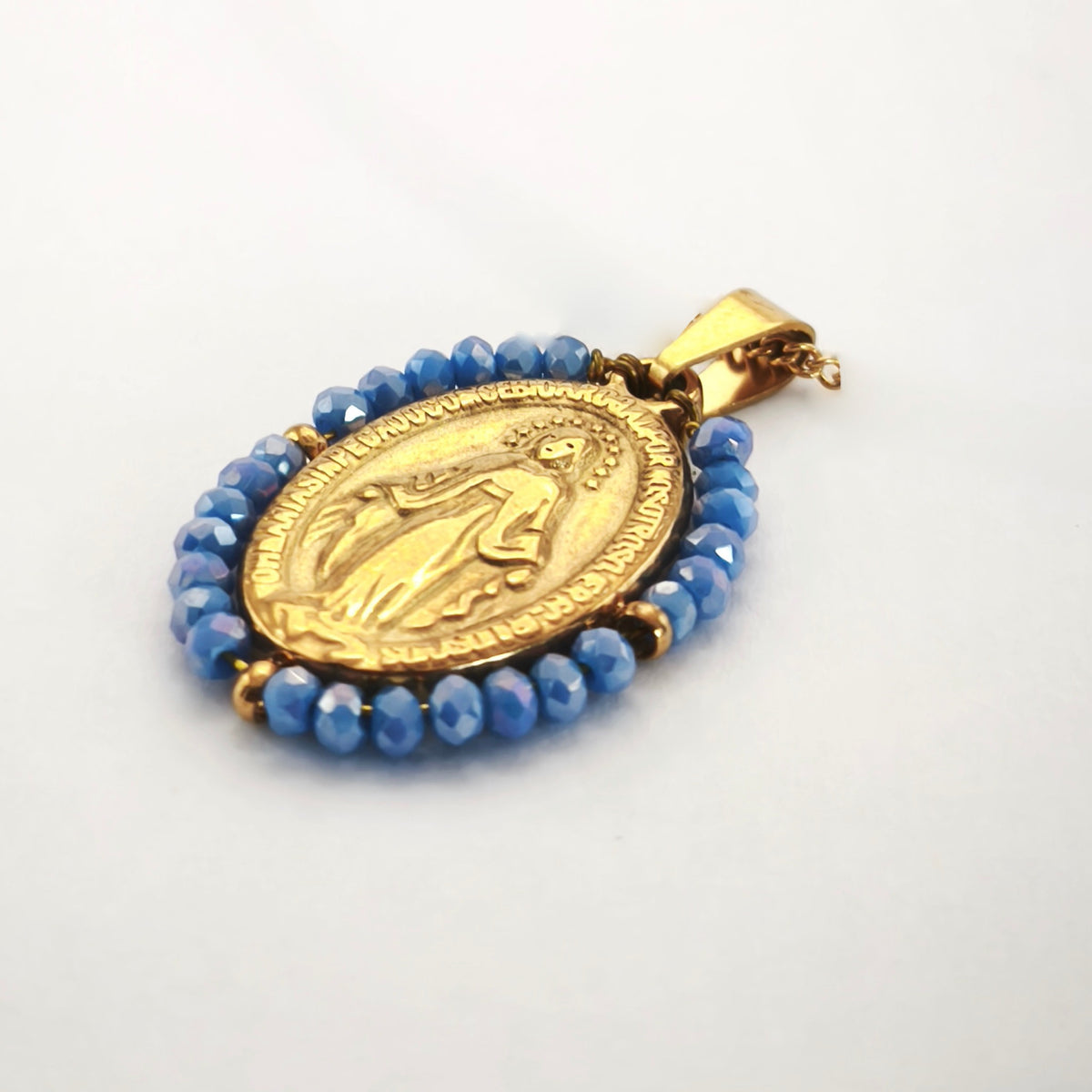 Pendente Auréola dourado, com medalha de Nossa Senhora das Graças rodeada de contas azul céu, em perspetiva.
