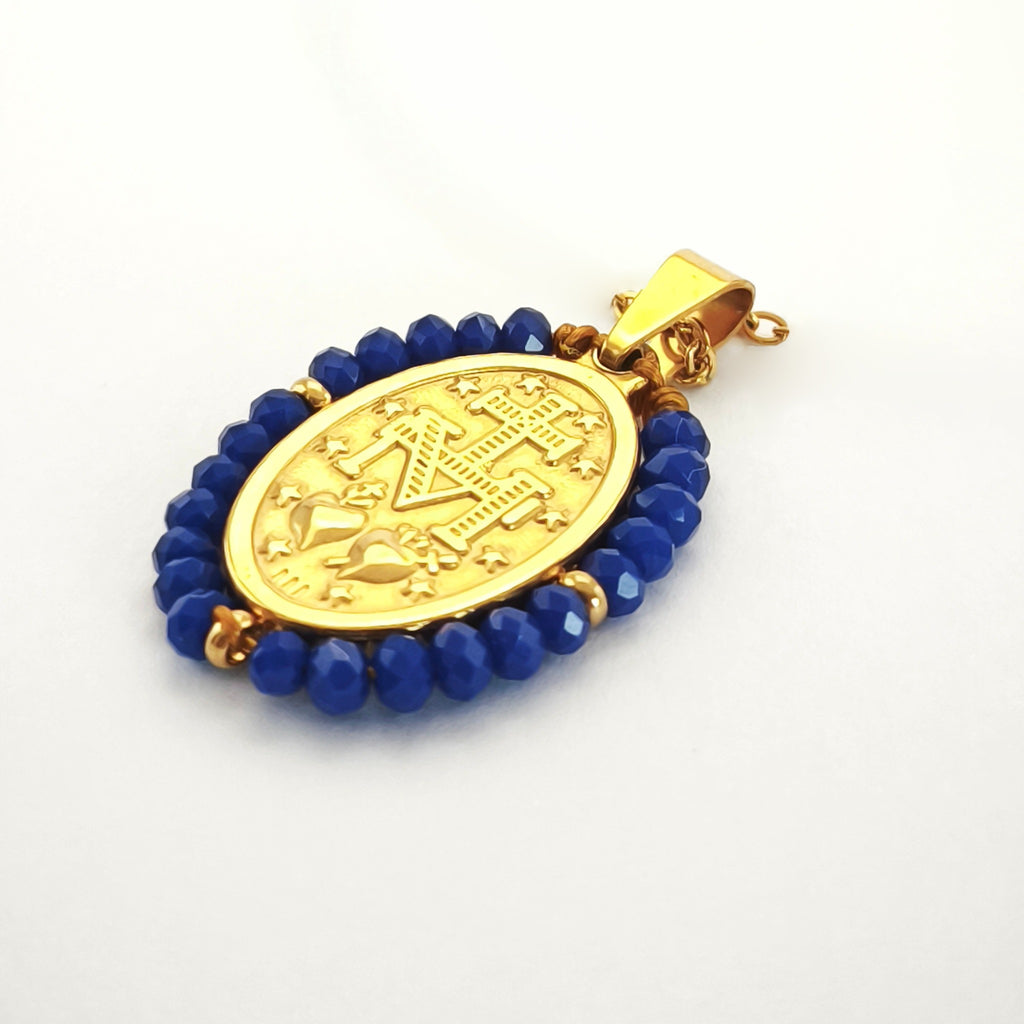 Pendente Auréola dourado, verso da medalha rodeada de contas azul cobalto, com a letra M, a cruz, os dois corações e as doze estrelas.