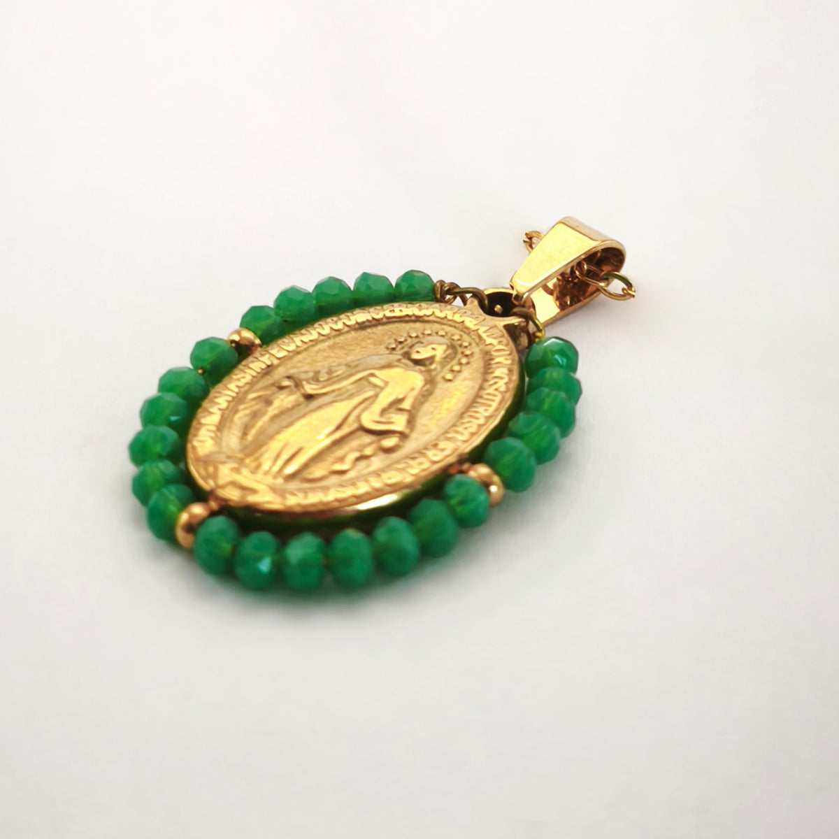 Pendente Auréola dourado, com medalha de Nossa Senhora das Graças rodeada de contas verdes, em perspetiva.