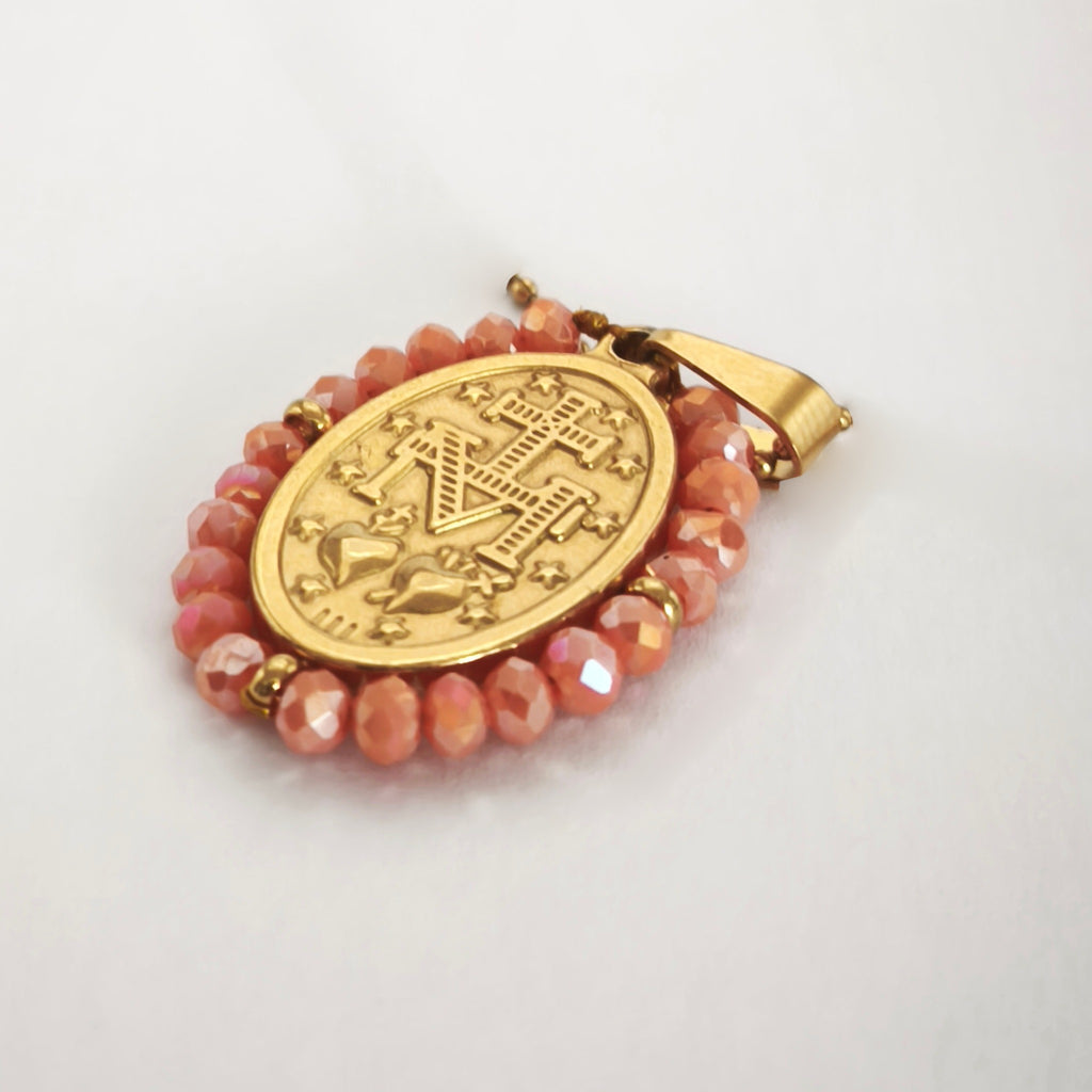 Pendente Auréola dourado, verso da medalha rodeada de contas salmão, com a letra M, a cruz, os dois corações e as doze estrelas.