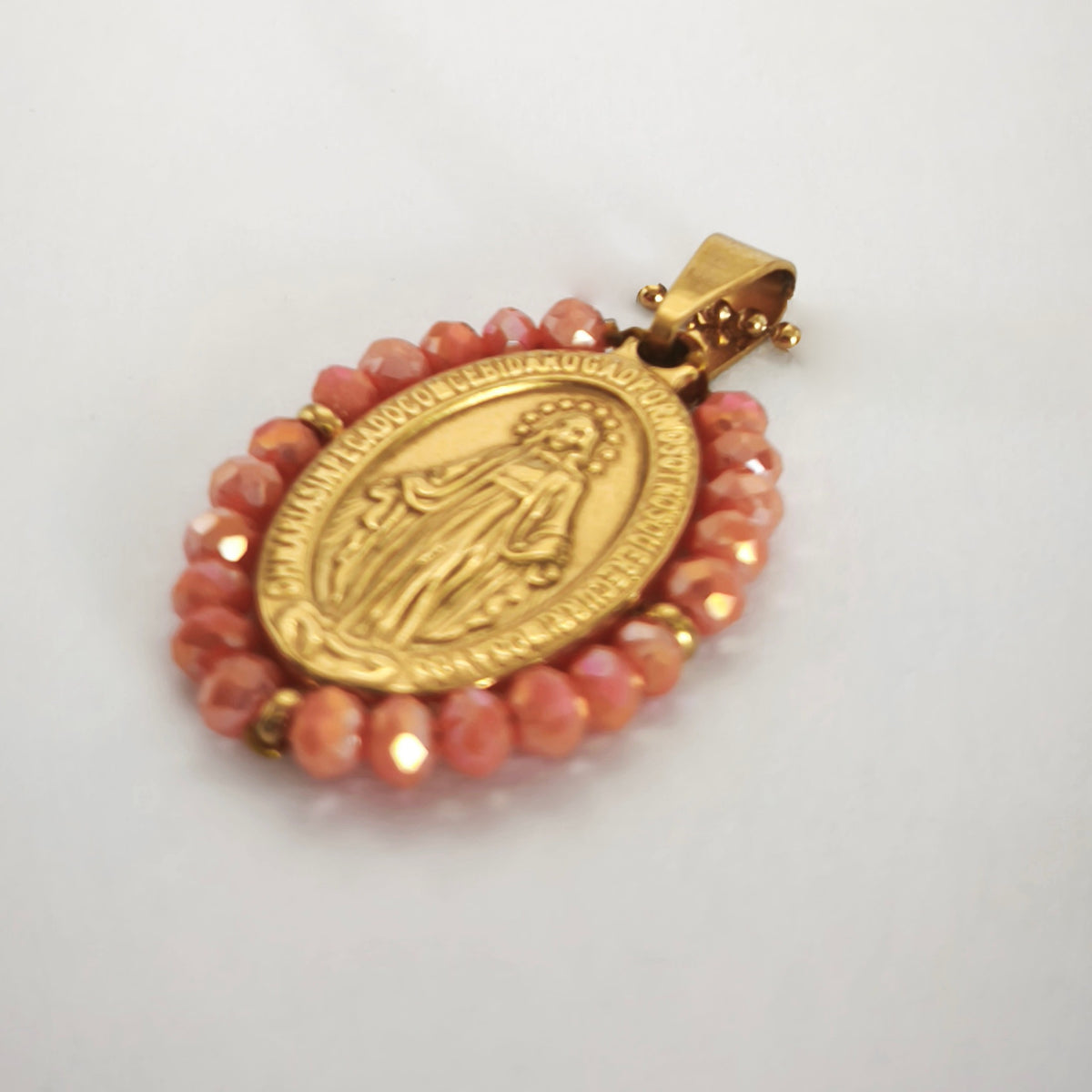 Pendente Auréola dourado, com medalha de Nossa Senhora das Graças rodeada de contas salmão, em perspetiva.
