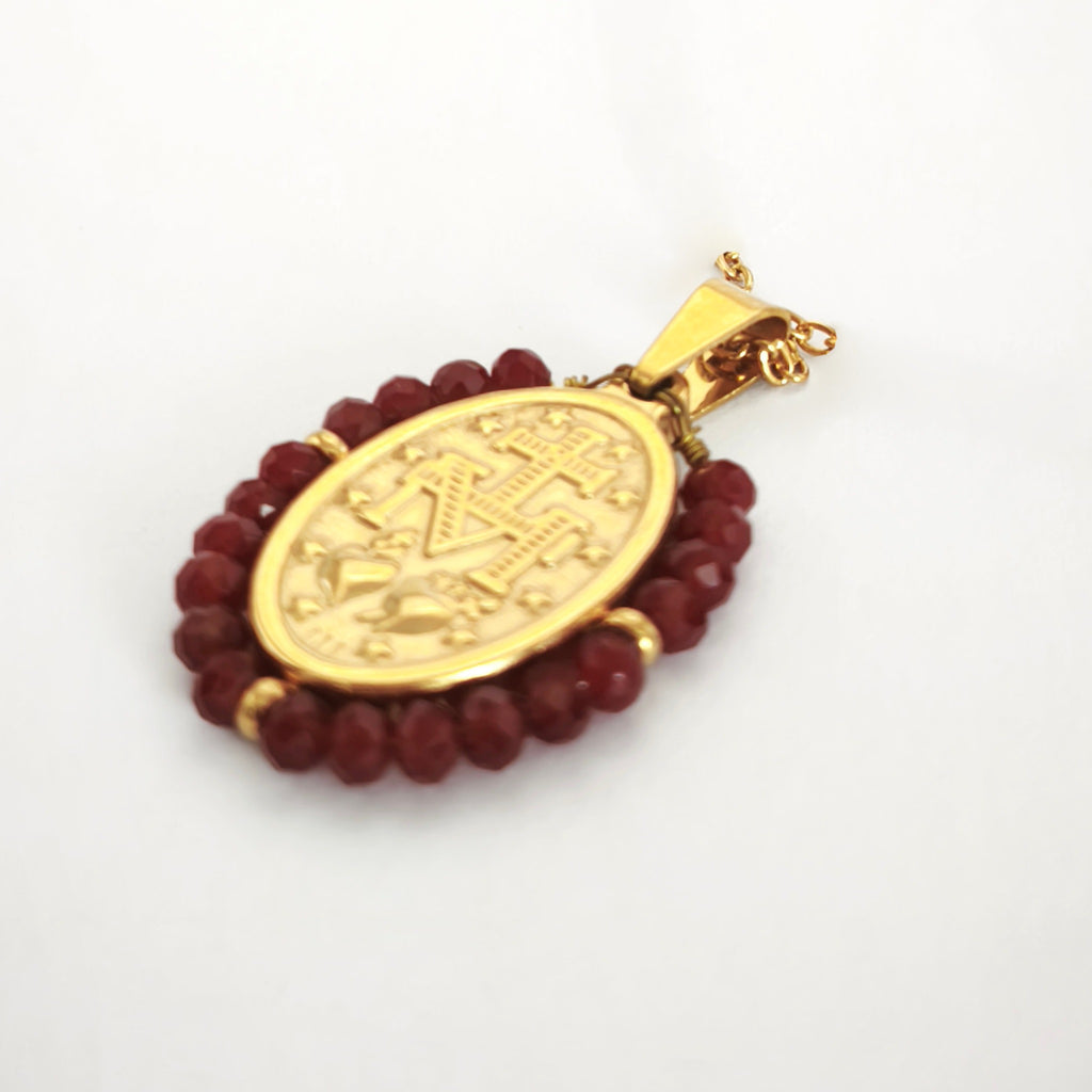Pendente Auréola dourado, verso da medalha rodeada de contas vinho, com a letra M, a cruz, os dois corações e as doze estrelas.