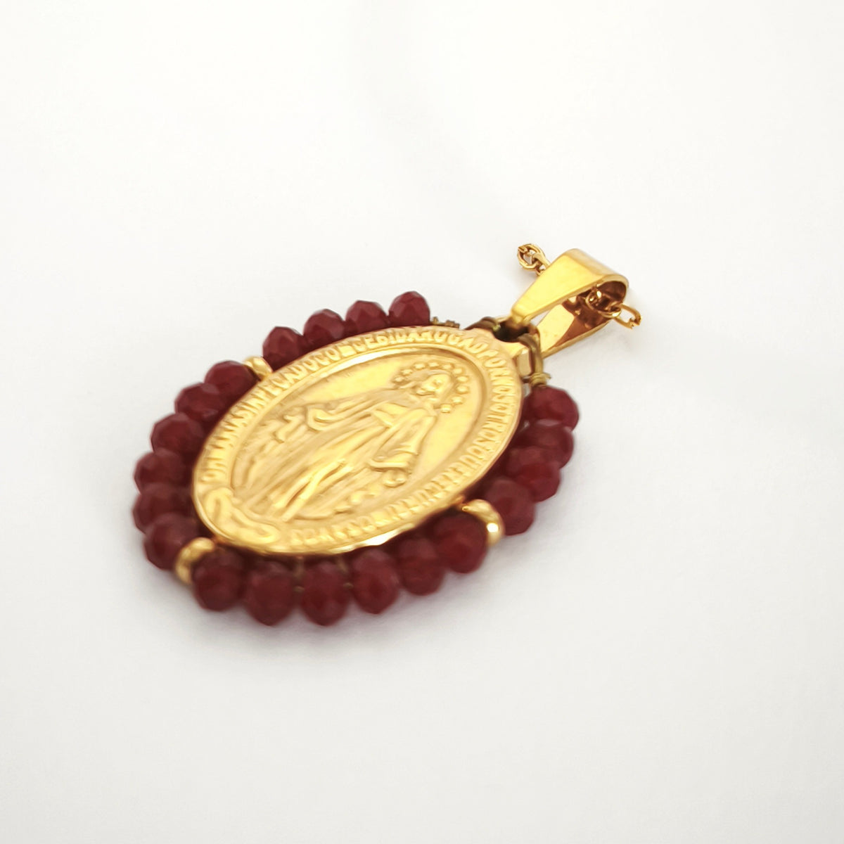 Pendente Auréola dourado, com medalha de Nossa Senhora das Graças rodeada de contas vinho, em perspetiva.