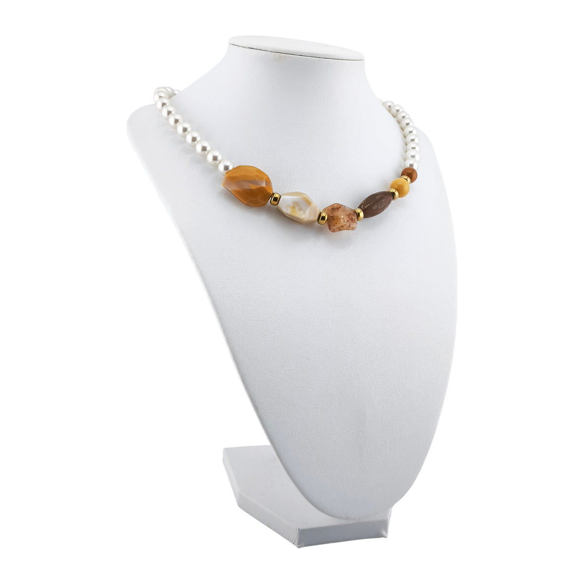 Colar Nascente Duna, com pérolas de concha e pedras naturais em ocre, amarelo-mel e creme, apresentado em expositor sobre fundo branco.