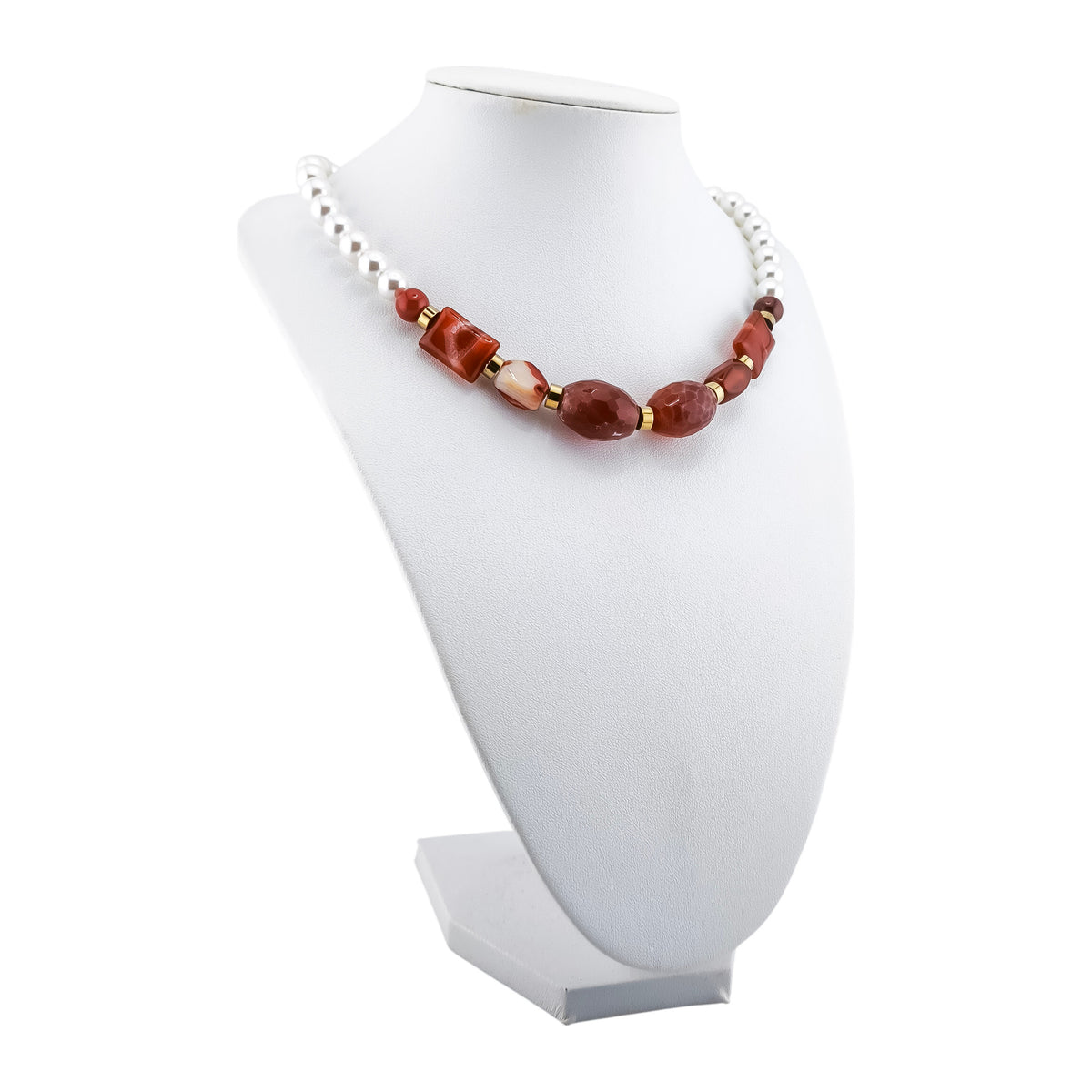 Colar Nascente Falésia, com pérolas de concha e pedras naturais em terracota, vermelho-telha e branco, apresentado em expositor sobre fundo branco.